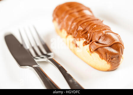 Bomba de cioccolato. Un tradizionale brasiliano eclair su uno sfondo bianco. Foto Stock