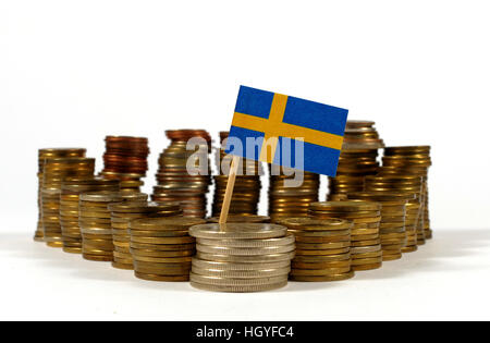 Bandiera della Svezia che ondeggia con pila di monete di denaro Foto Stock