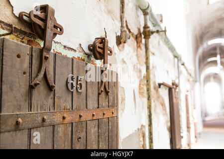 Porta di legno della vecchia cella di prigione closeup. Foto Stock