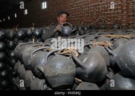 Shijiazhuang cinese nella provincia di Hebei. Xiii gen, 2017. Artigiano Wang Qijie controlla il Qingsha pentole a un workshop in Baihedong villaggio di Yuxian county, a nord della Cina di nella provincia di Hebei, Gennaio 13, 2017. Qingshaqi, o argilla verde utensili tradizionali sono prodotti artigianali con più di trecento anni di storia. Gli utensili sono fatti di Gantu, un tipo di suolo locale e sono stati utilizzati per la cottura e il punto di ebollizione. La realizzazione della Qingshaqi è diventata una provinciale patrimonio culturale immateriale. Credito: Yang Shiyao/Xinhua/Alamy Live News Foto Stock