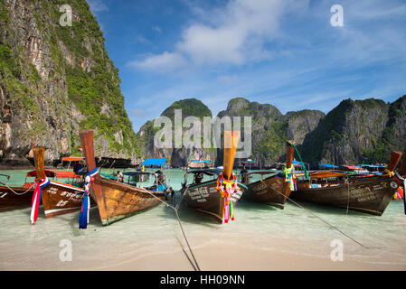 KRABI, Tailandia - 4 dicembre, 2015: long-tailed barche per i turisti sono ancorati lungo la spiaggia di Maya che è la principale attrazione di Phi Phi Island. Foto Stock