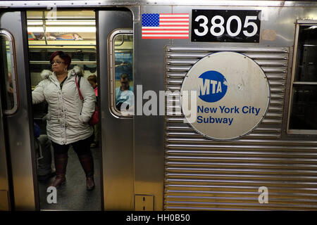 Una donna si erge su di una New York City metropolitana treno come le porte iniziano a chiudersi. 01/11/17 Foto © Andy Buchanan 2017 Foto Stock