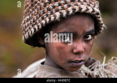 Simien Mountains National Park, Amhara Region, Nord Etiopia. Ritratto di un bambino accanto alle montagne del Simien. Le bellezze delle Simien mountai Foto Stock