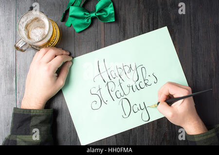 L'uomo la scrittura di una felice Festa di San Patrizio card Foto Stock