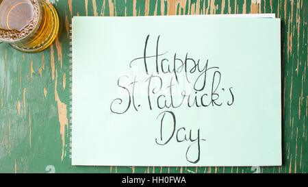 Happy St Patrick giorno scheda di calligrafia e bicchiere di birra Foto Stock