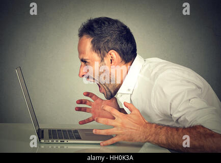 Collera furiosa business man urlando al computer. Negative le emozioni umane, le espressioni del viso, sentimenti, aggressione, gestione di rabbia concetto problemi Foto Stock