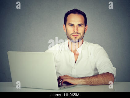 Sorridente giovane uomo d affari usando un computer portatile Foto Stock