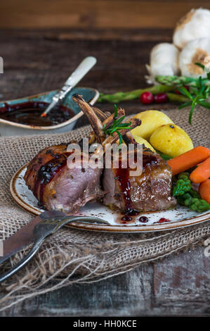 Rack di arrosto di costolette di agnello con verdure e salsa al vino rosso Foto Stock