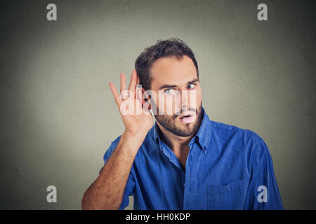 Ritratto di uomo bello segretamente in ascolto sulla conversazione privata. Volto umano, espressione, emozione, il linguaggio del corpo Foto Stock