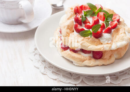 Pavlova cake con fragole fresche su uno sfondo di legno Foto Stock