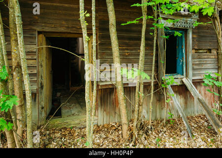 Area di esclusione dopo la tragedia di Cernobil, la contaminazione nucleare. Chiudere l'ingresso fatiscente di legno vecchio Country House con pavimento in rovina e finestra Foto Stock