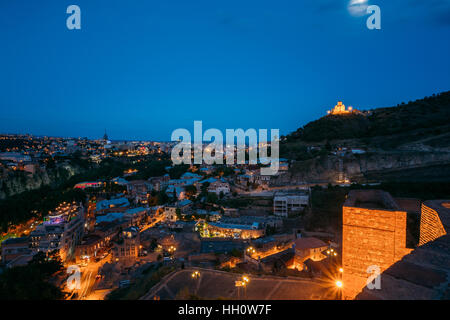 Vista superiore della illuminata Tbilisi, Abanotubani distretto e Tabor il monastero della Trasfigurazione, costruito su Taboris Mta o Tabor (favore) Monte. Ev blu Foto Stock