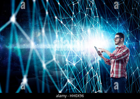 Hipster guy contro media technologies sfondo utilizzando dispositivo tablet pc. I supporti misti Foto Stock