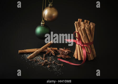 Bastoncini di cannella, anice stellato e chiodi di garofano con due baubles di Natale Foto Stock