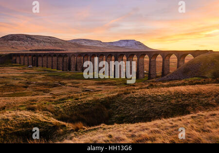 Tramonto sul viadotto Ribblehead sul Settle-Carlisle linea ferroviaria con Ingleborough dietro Foto Stock