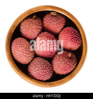 Il Lychee o litchi frutti nella ciotola di legno. Con la buccia rosso maturo Litchi chinensis, chiamato anche liechee, liche, lizhi o li zhi. Foto Stock