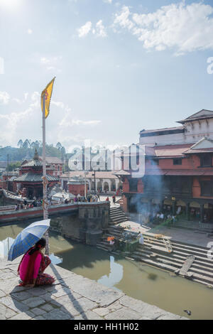 La vedova che si affaccia la masterizzazione rituale del marito presso il tempio di Pashupatinath a Kathmandu in Nepal Foto Stock