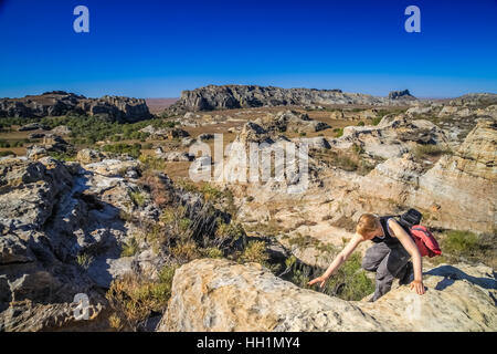 Unica donna trekking attraverso la grande roccia in Isalo National Park in Madagascar Foto Stock