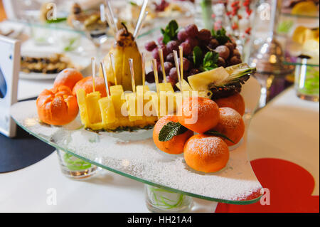 Tangerini su una tavola festiva. Frutti Esotici sul tavolo. Frutti che serve a una festa di capodanno e la tavola del Natale Foto Stock