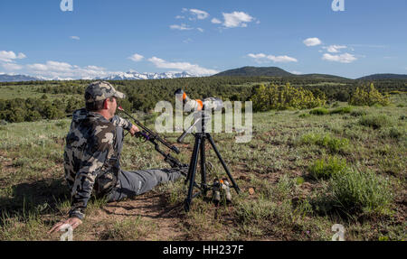 All'aperto uomo seduto vicino al suo cannocchiale guardando al lato del paese nella parte occidentale di Colorado Foto Stock