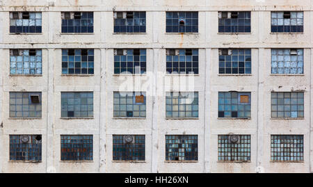 Windows in una facciata di una vecchia fabbrica trascurato la costruzione di Foto Stock