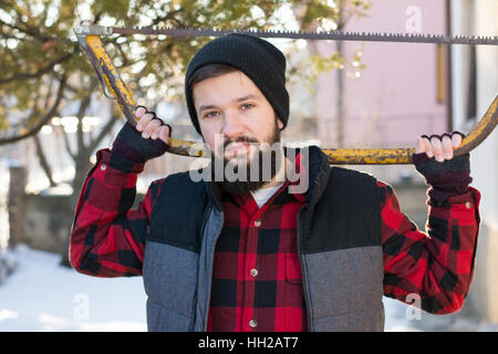 Uomo con una sega a mano per il taglio di legno in cantiere Foto Stock