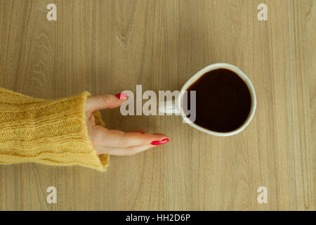 Donna con mano manicure rosso sta per prendere una tazza di caffè Foto Stock