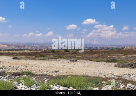 Estate colpo di Lady's Mile a Limassol e mostra prosciugato Lago letto con misty vista urbano e le montagne sullo sfondo. Foto Stock