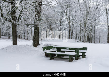 In legno Tavolo picnic con panche dopo la nevicata Foto Stock