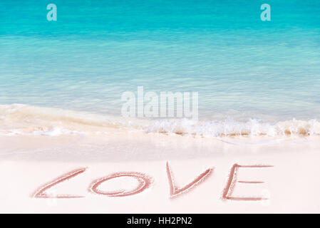 Amore scritto sulla sabbia bianca di una spiaggia idilliaca Foto Stock