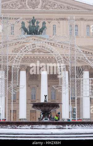 Mosca, Russia. Domenica, 15 gennaio 2017. Fontana di surgelati e le decorazioni di Natale nella parte anteriore del Bolshoi (Grand Theatre. Apollo quadriga sulla parte superiore del tetto. Wet, ventoso e nevoso domenica a Mosca. La temperatura è di circa -2C (28F). Nuvole pesanti, bufera di neve. Pulitori per strada e la pulizia della neve veicoli sono occupato. © Alex Immagini/Alamy Live News Foto Stock