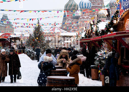 Mosca, Russia. Domenica, 15 gennaio 2017. Persone non identificate hanno qualche snack al fun-fiera sulla Piazza Rossa. Cattedrale di San Basilio in background. Wet, ventoso e nevoso domenica a Mosca. La temperatura è di circa -2C (28F). Nuvole pesanti, bufera di neve. Pulitori per strada e la pulizia della neve veicoli sono occupato. © Alex Immagini/Alamy Live News Foto Stock