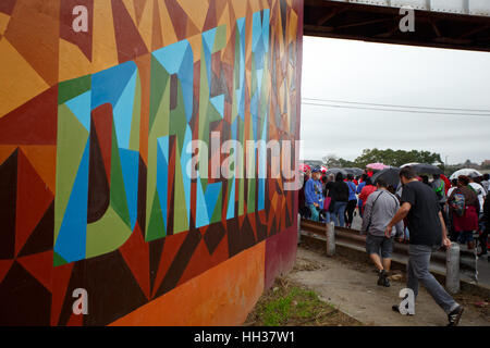 San Antonio, Stati Uniti d'America. 16 gennaio, 2017. Dimostranti a piedi passato un murale lungo il Martin Luther King Drive durante l annuale Martin Luther King Jr. Marzo a San Antonio, Texas. Diverse migliaia di persone hanno partecipato alla città del trentesimo anniversario marzo celebra U.S. leader dei diritti civili Martin Luther King Jr. Credito: Michael Silver/Alamy Live News Foto Stock