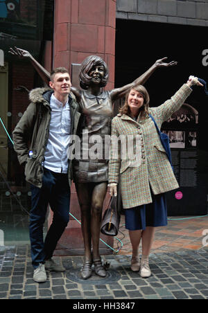 Liverpool, Regno Unito. 16 gennaio, 2017. Una grande statua in bronzo di Cilla Black è stato svelato su Mathew Street, Liverpool per celebrare il sessantesimo anniversario del Cavern Club. La statua fu donata alla città di Liverpool da Cilla ha tre figli, che hanno partecipato all'inaugurazione. Due membri del pubblico stand su entrambi i lati della statua. Credito: Pak Hung Chan/Alamy Live News Foto Stock