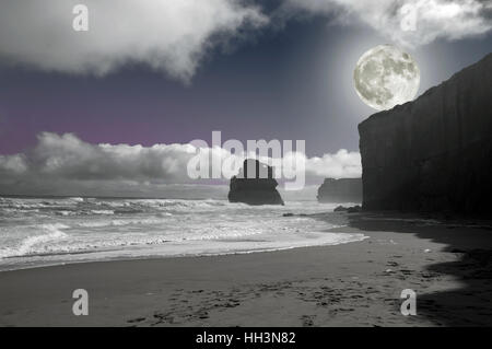 Costa rocciosa dell'oceano di notte nella luce della luna piena Foto Stock