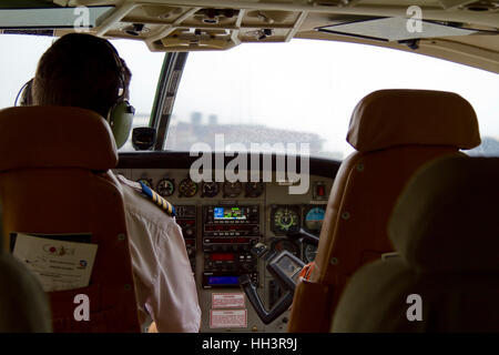 Selous, Tanzania - Gennaio 20, 2015: Cockpit colpo di un in-flight Airways costiere Cessna C208B aereo con un pilota Foto Stock