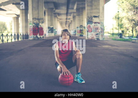 Giovane giocatore di basket in città situazione metropolitana Foto Stock