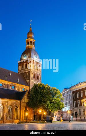 Riga, Lettonia. Vista della piazza del Duomo e la cupola della cattedrale di illuminazione serale sotto il cielo blu. Antico monumento medievale della Città Vecchia, Architettonico Heri Foto Stock