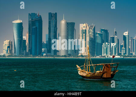 Dhow tradizionale imbarcazione a vela con il settore finanziario skyline dietro, Doha, Qatar Foto Stock