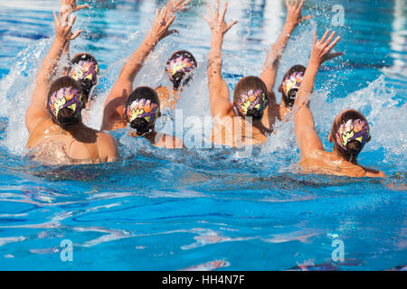 Nuoto sincronizzato team di eseguire una routine di sincronizzato di elaborare si muove in acqua Foto Stock