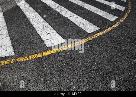 Attraversamento pedonale la segnaletica stradale zebra, strisce bianche e gialle la linea di confine sul nero asfalto, foto di sfondo Foto Stock