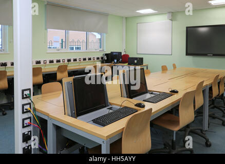 Postazioni computer in una nuova scuola secondaria in aula di tecnologia. Mostra i computer nascosto in speciali banchi di piegatura Foto Stock