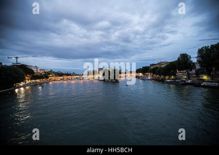 Alba di un mattino nuvoloso a Parigi in Francia con Ile de la Cite e Pont Neuf. Il fiume Senna riflette il cielo violetto e luci della citta'. Foto Stock