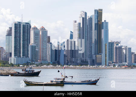 Giugno 15, 2016 Panama City, Panama: piccole barche da pesca galleggianti sull'acqua dal mercato del pesce con il moderno centro citta' highrise edifici del bac Foto Stock