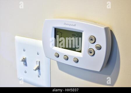 Un termostato elettronico sul muro di una casa residenziale Foto Stock