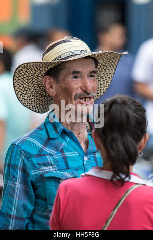 2 ottobre 2016 El Jardin ,Colombia: un uomo con il tradizionale cappello di paglia chiamato sombrero vueltiao avente una conversazione di strada Foto Stock