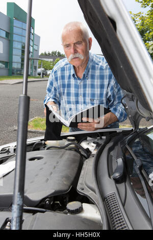 L'uomo anziano la manutenzione della sua auto a casa Foto Stock