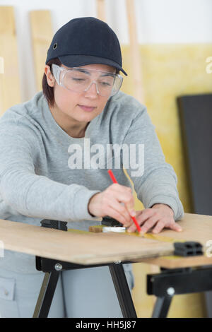 Ritratto di donna felice falegname redazione nuovo progetto in officina Foto Stock