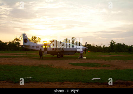 Selous, Tanzania - 20 Gennaio 2015: A Coastal Airways Cessna C208B aereo presso la Riserva Selous al tramonto. Il piccolo aereo è usato per prendere tou Foto Stock