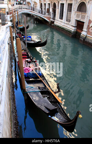 Una linea di gondole attraccate su un canale di Venezia, Italia Foto Stock